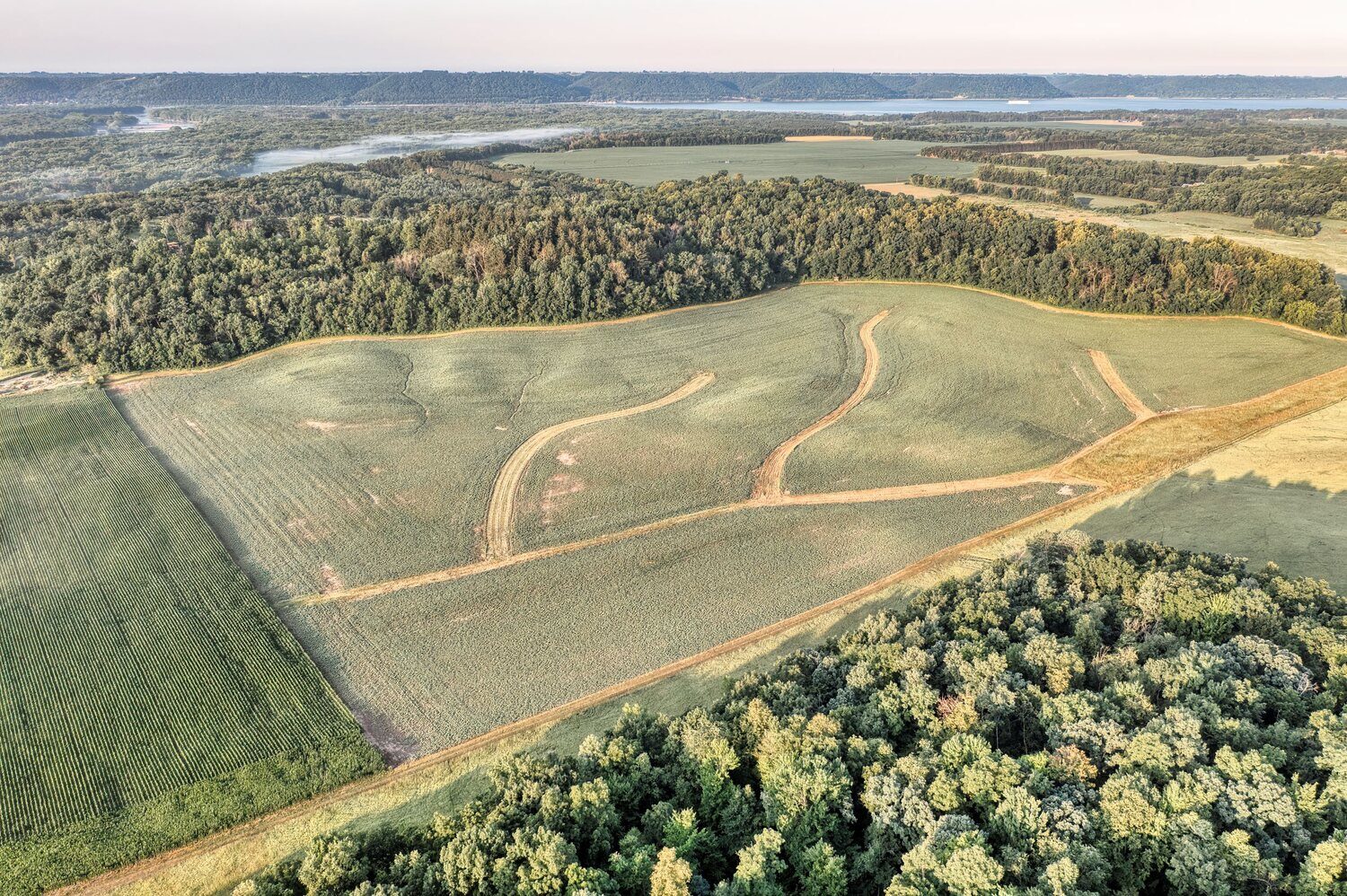 Aerial view of farmland, timber, and a river valley held as a land investment